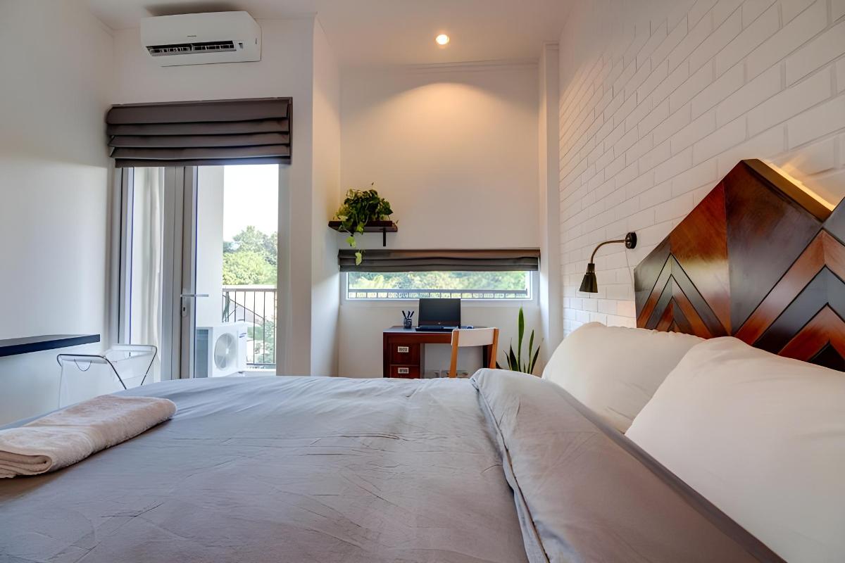 Kamar Studio dengan AC, tirai, dan pintu kaca menuju balkon